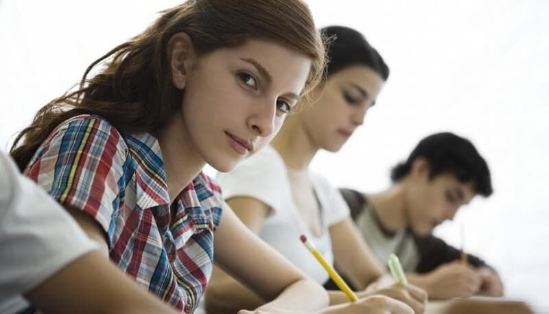 3 étudiants écrivant