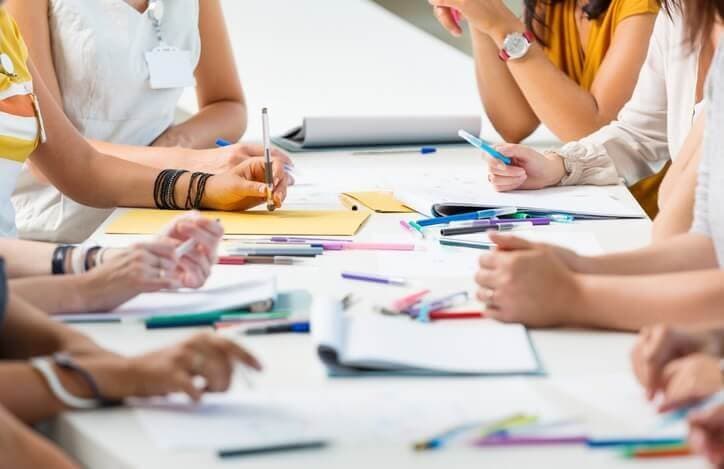 Les gens discutent pendant que leurs notes et leurs stylos sont sur la table
